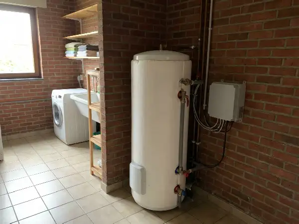 Chauffe-eau électrique piloté par un petit boîtier dans une buanderie
